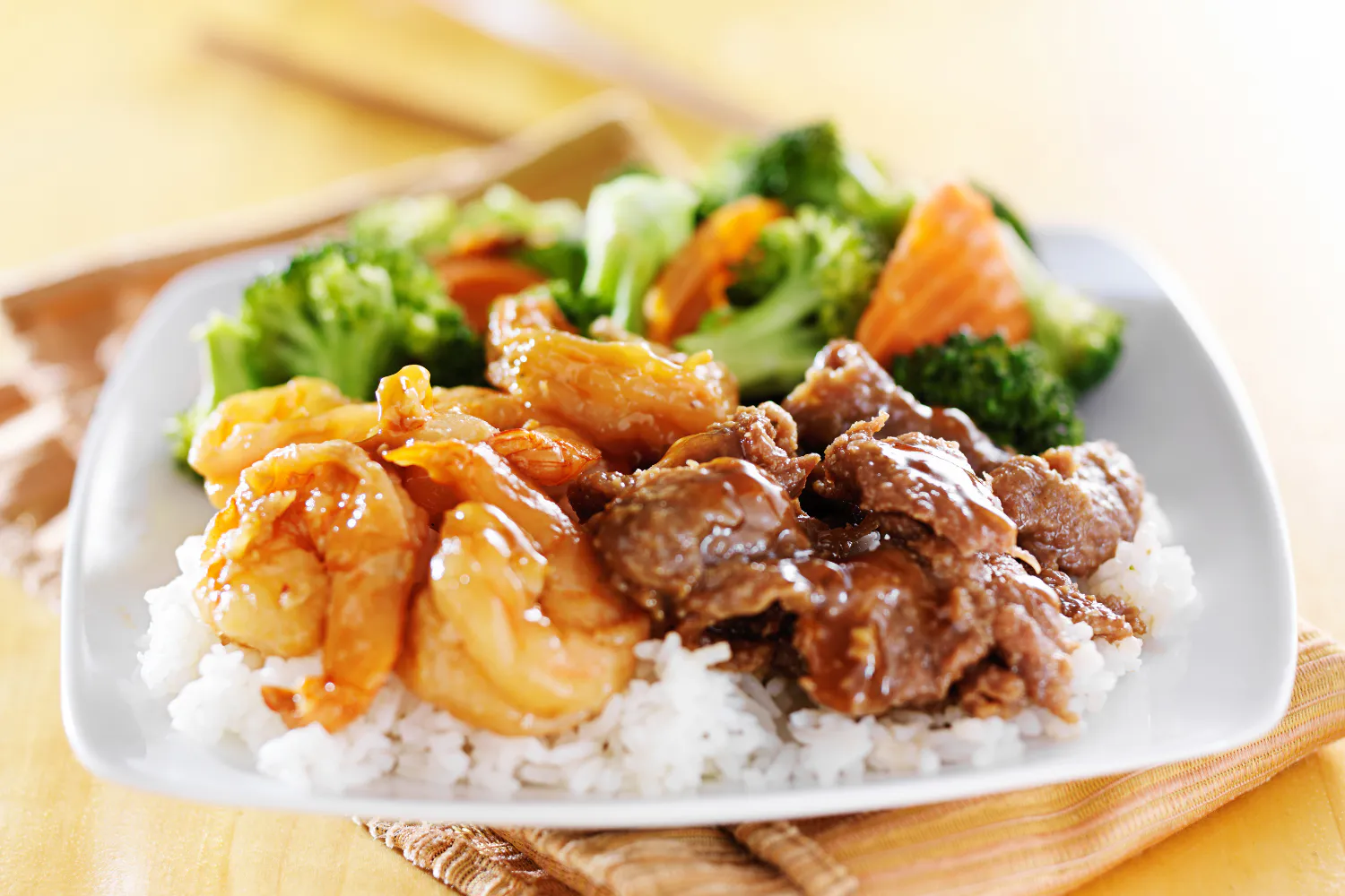Combination rice plate with glazed shrimp, beef and steamed broccoli florets at O E C Asian Fusion Restaurant in Picayune