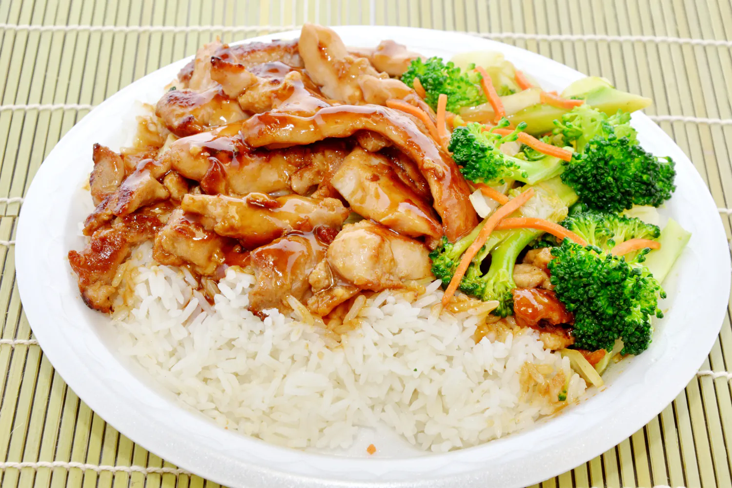 Teriyaki chicken rice platter with broccoli, carrot strips and glossy savory sauce at O E C Asian Fusion Restaurant in Picayune