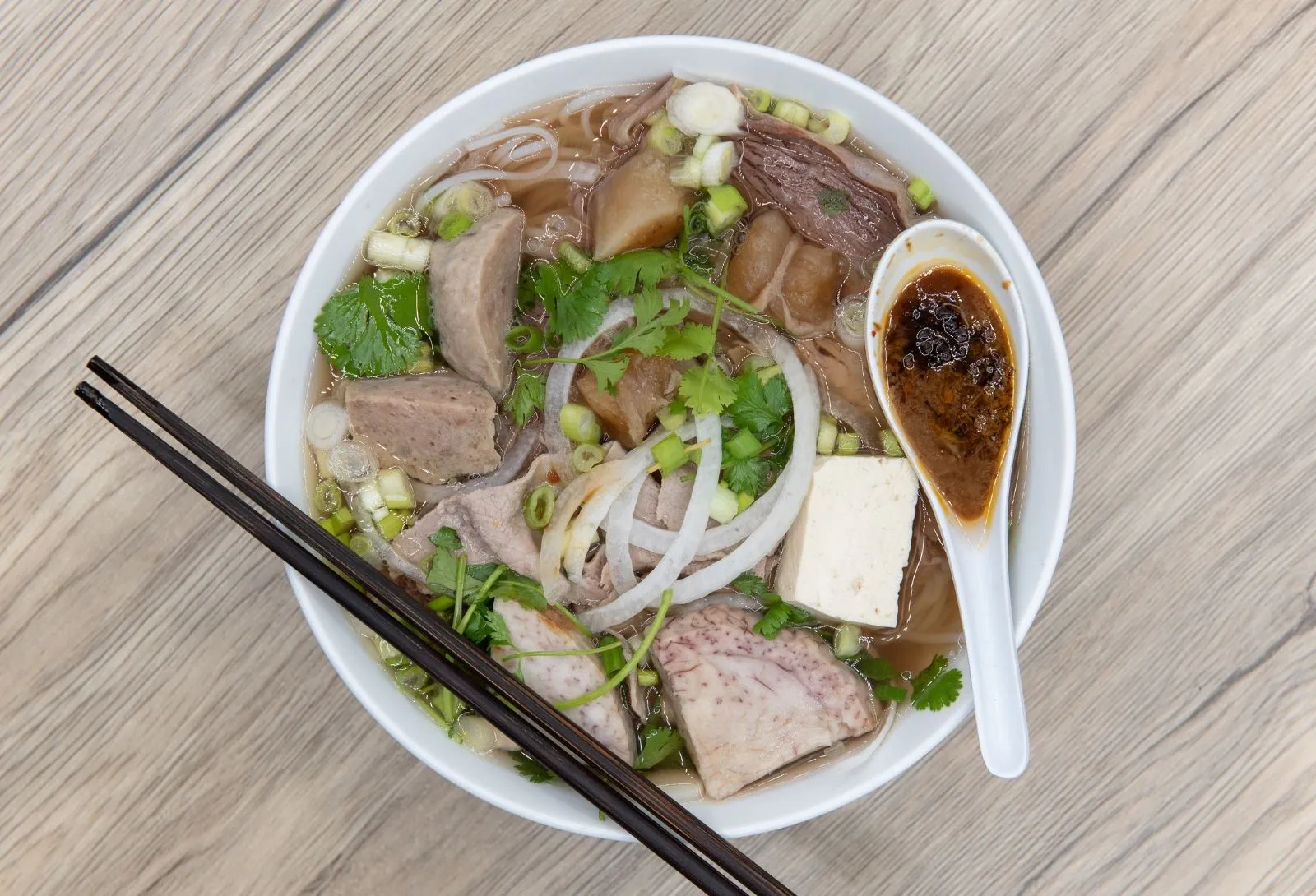 Vietnamese beef pho rice noodle soup with meatballs, tofu and chili dipping sauce at O E C Asian Fusion Restaurant in Picayune